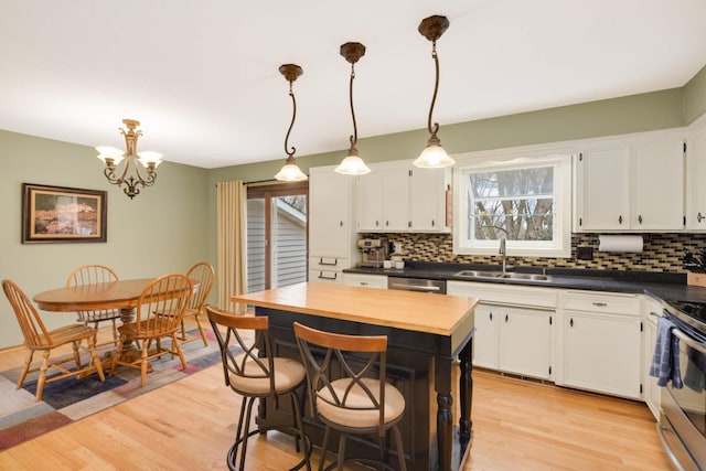 kitchen with white cabinetry, appliances with stainless steel finishes, tasteful backsplash, and a sink
