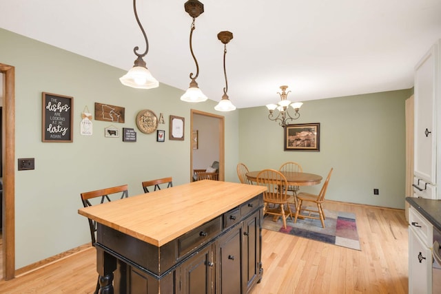 dining room featuring light wood-style flooring and a notable chandelier