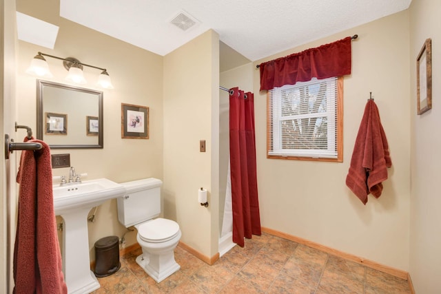 full bath with toilet, baseboards, visible vents, a sink, and a shower with shower curtain