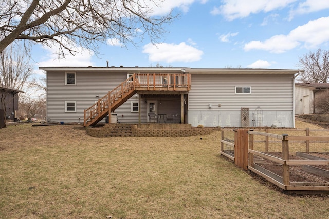back of house with a lawn, stairs, a wooden deck, and fence