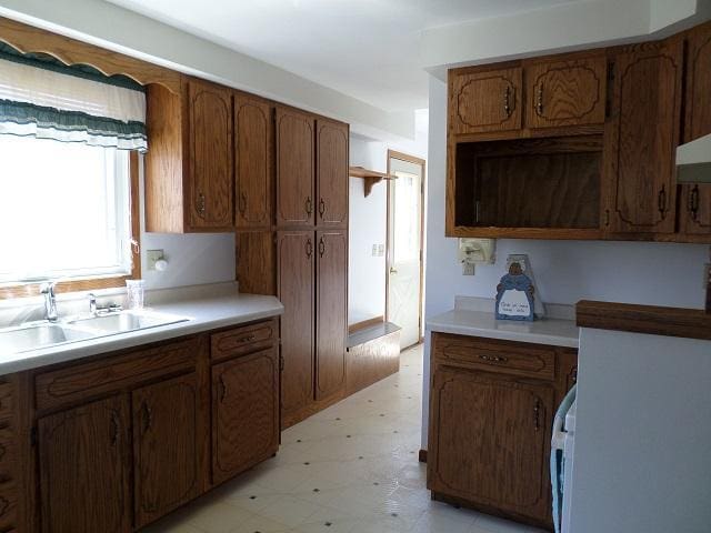 202 Buse Ave NE, Red Lake Falls, MN 56750 - kitchen with a sink, brown cabinetry, light floors, and light countertops