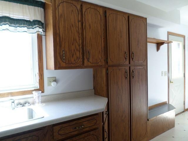 202 Buse Ave NE, Red Lake Falls, MN 56750 - kitchen featuring brown cabinetry, light countertops, open shelves, and a sink
