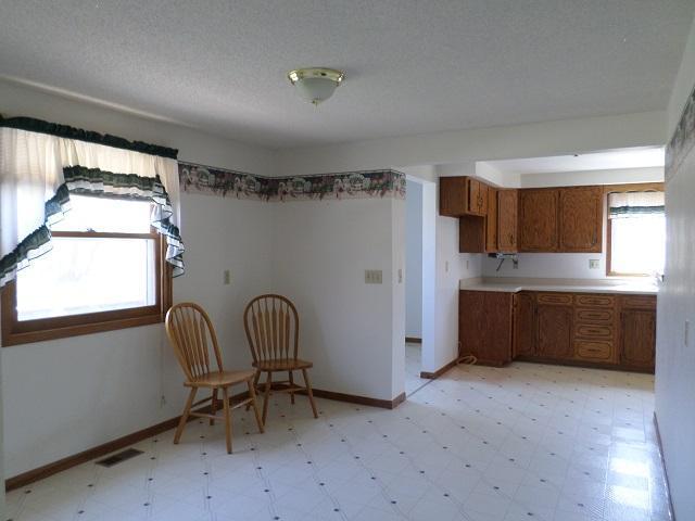 202 Buse Ave NE, Red Lake Falls, MN 56750 - kitchen featuring brown cabinetry, light floors, baseboards, and visible vents