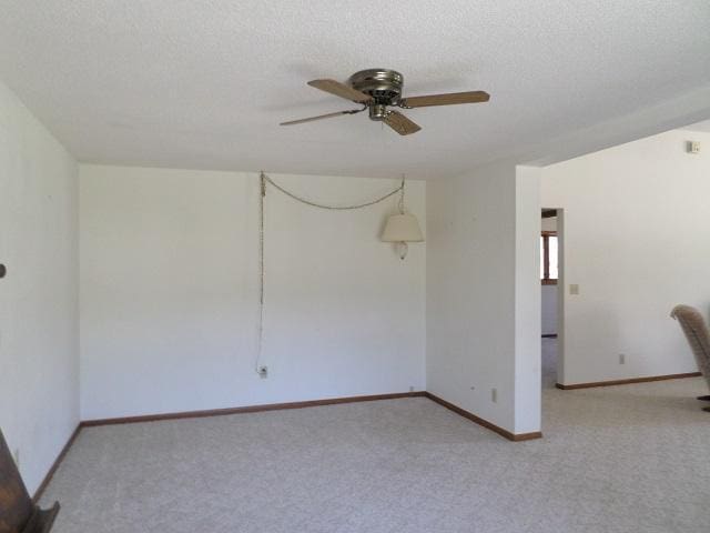 202 Buse Ave NE, Red Lake Falls, MN 56750 - unfurnished room with baseboards, carpet flooring, ceiling fan, and a textured ceiling