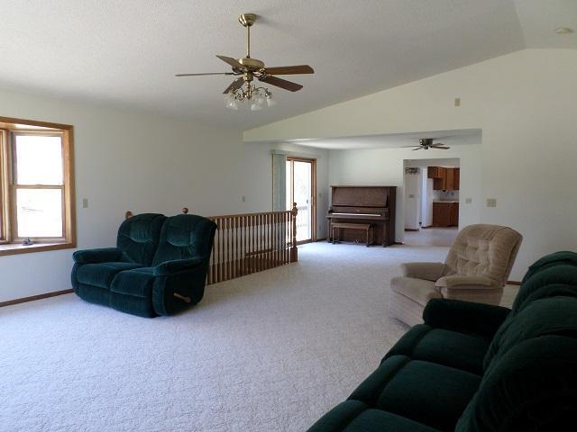 202 Buse Ave NE, Red Lake Falls, MN 56750 - living room with vaulted ceiling, carpet flooring, and a ceiling fan