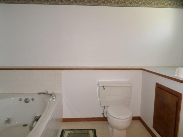 202 Buse Ave NE, Red Lake Falls, MN 56750 - bathroom with toilet, a tub with jets, and baseboards