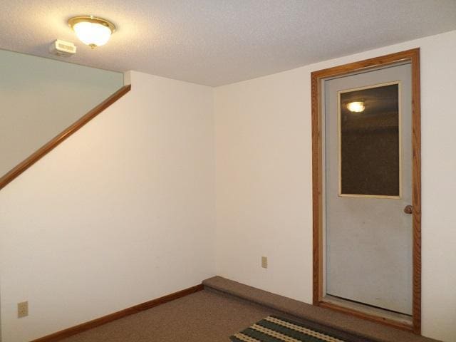 202 Buse Ave NE, Red Lake Falls, MN 56750 - spare room featuring dark carpet and a textured ceiling
