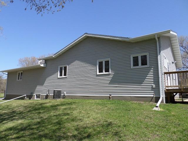 202 Buse Ave NE, Red Lake Falls, MN 56750 - rear view of house with a yard, a wooden deck, and central AC