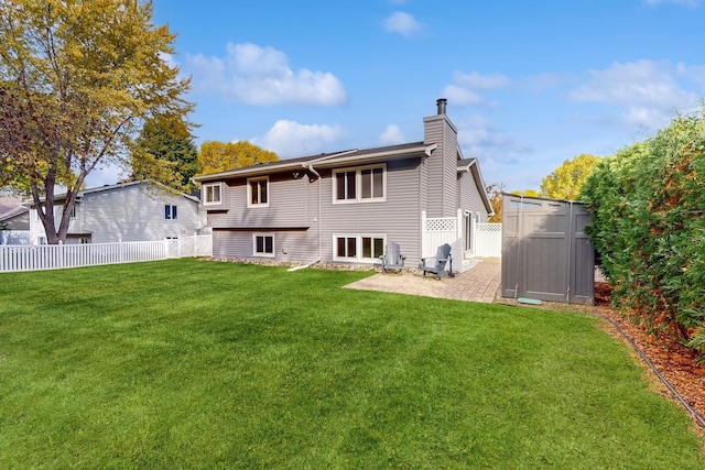 back of property with a fenced backyard, a patio area, a chimney, and a lawn