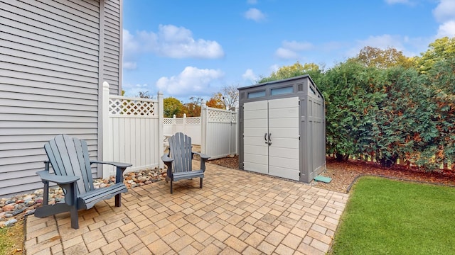 view of patio featuring an outbuilding, a shed, and fence