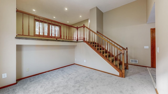 stairway featuring baseboards, recessed lighting, visible vents, and carpet