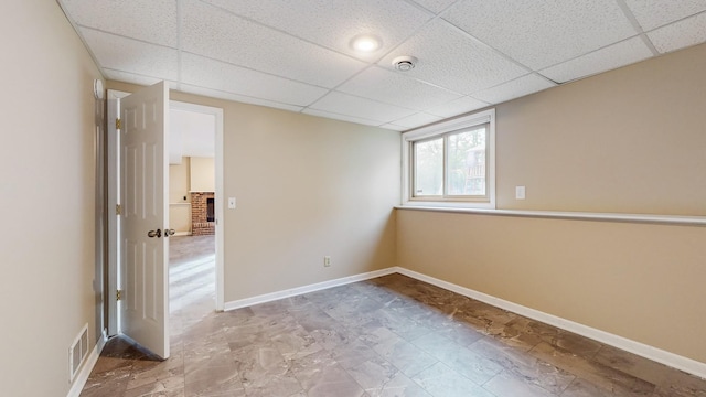 unfurnished room featuring a paneled ceiling, baseboards, and visible vents