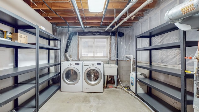 laundry area featuring washer and clothes dryer, laundry area, and a sink