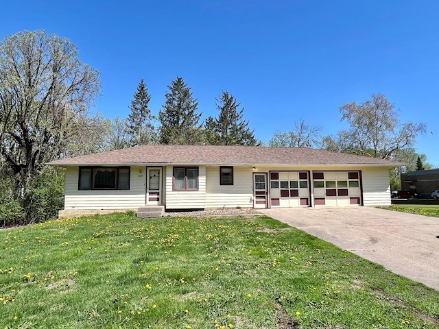 ranch-style home featuring an attached garage, concrete driveway, a front yard, and entry steps