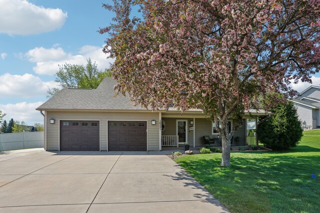 view of property hidden behind natural elements featuring concrete driveway, a garage, a porch, and roof with shingles