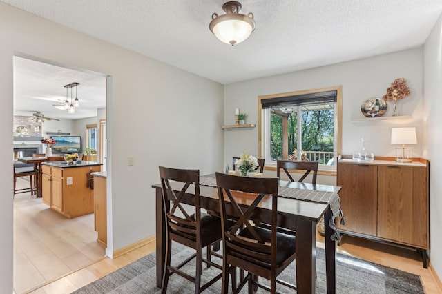dining area with light wood-type flooring and a textured ceiling