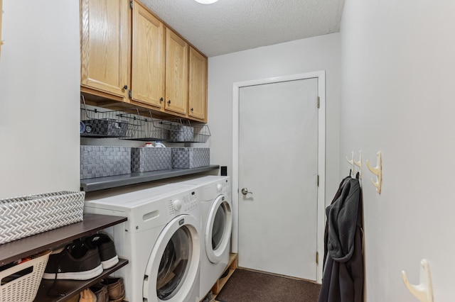 clothes washing area featuring separate washer and dryer, cabinet space, and a textured ceiling