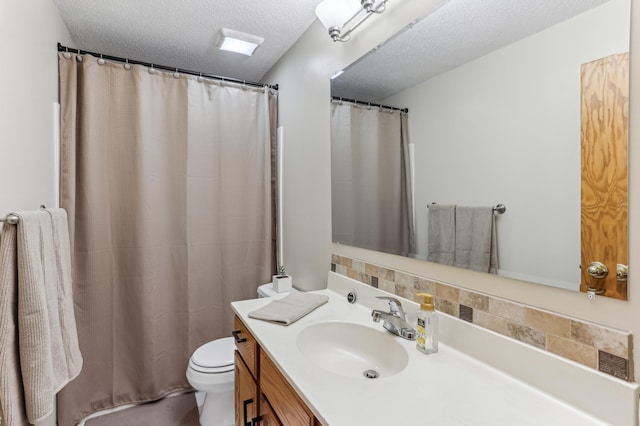 bathroom featuring toilet, vanity, and a textured ceiling