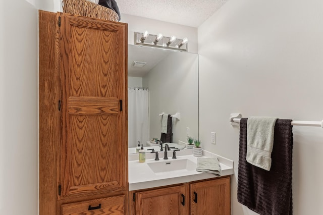 bathroom with a textured ceiling and vanity