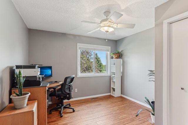 office space with light wood-style floors, ceiling fan, a textured ceiling, and baseboards