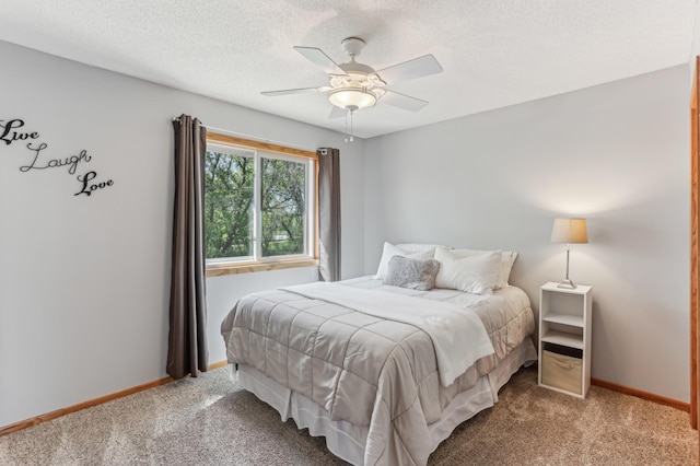 carpeted bedroom featuring baseboards, a ceiling fan, and a textured ceiling
