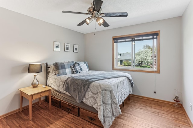 bedroom featuring wood finished floors, baseboards, and ceiling fan