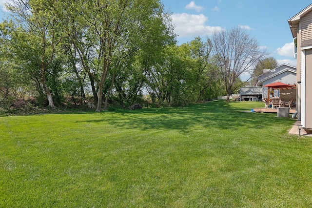 view of green lawn featuring a wooden deck and a gazebo