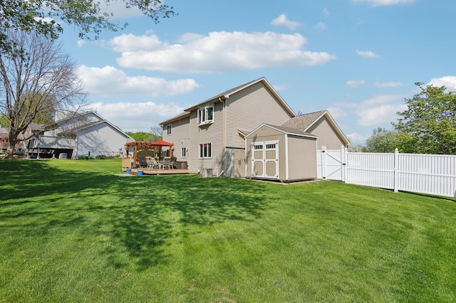 back of house with a deck, a storage unit, and an outdoor structure