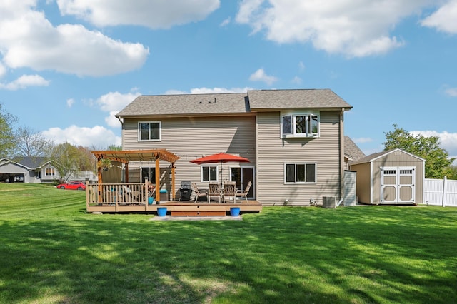 back of house featuring a pergola, a storage unit, a wooden deck, an outbuilding, and a lawn