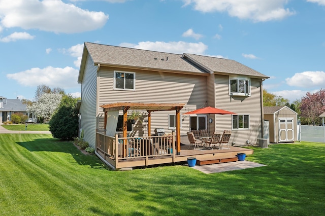 back of house with a shed, a deck, a pergola, and an outbuilding