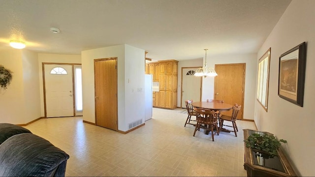 entryway featuring a chandelier and baseboards
