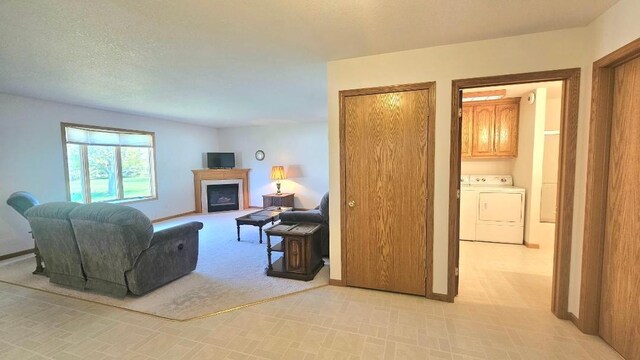 living room with washing machine and dryer, a fireplace, and baseboards