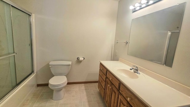 full bathroom featuring baseboards, toilet, vanity, and enclosed tub / shower combo