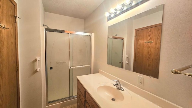 bathroom featuring a shower stall and vanity