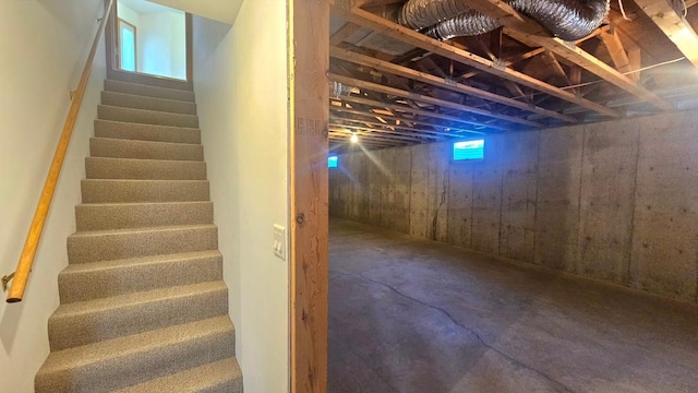staircase with unfinished concrete floors
