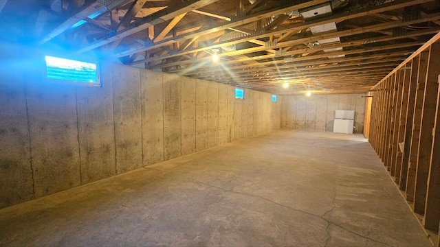 below grade area featuring freestanding refrigerator