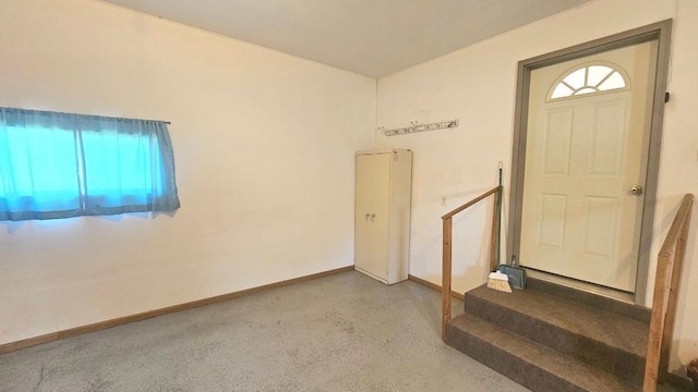 entrance foyer featuring concrete flooring and baseboards