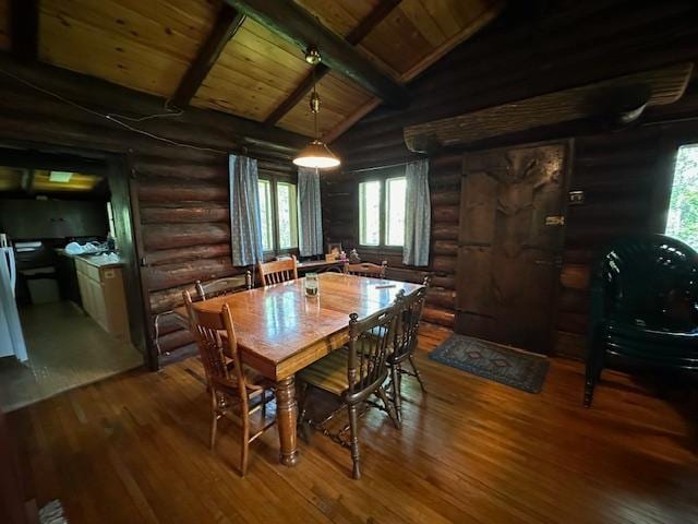 dining area featuring hardwood / wood-style floors, rustic walls, vaulted ceiling with beams, and wooden ceiling