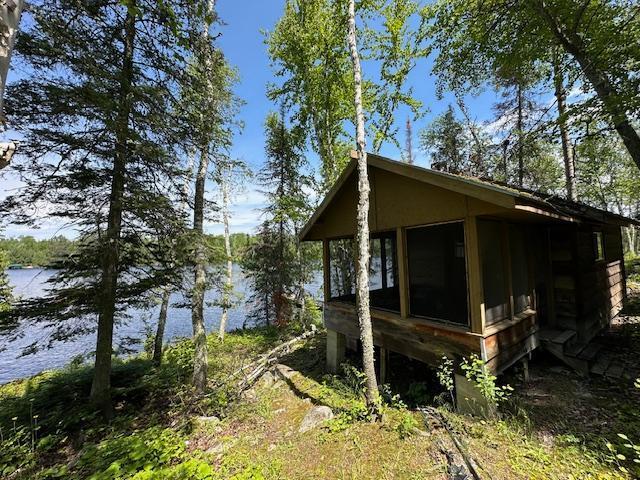 view of side of property with a sunroom and a water view