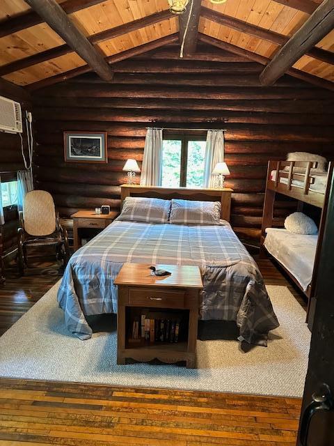 bedroom with wood ceiling, rustic walls, lofted ceiling with beams, and hardwood / wood-style floors