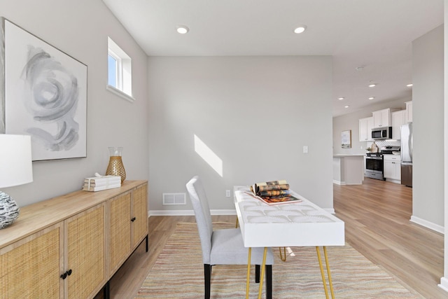 dining area with light wood-type flooring, recessed lighting, and baseboards