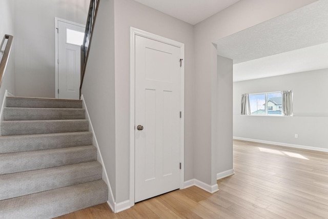 stairway featuring wood finished floors and baseboards
