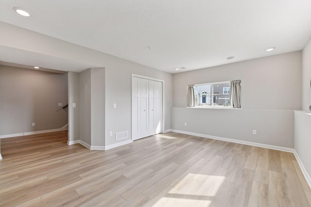 unfurnished bedroom featuring light wood-style floors, baseboards, a closet, and recessed lighting