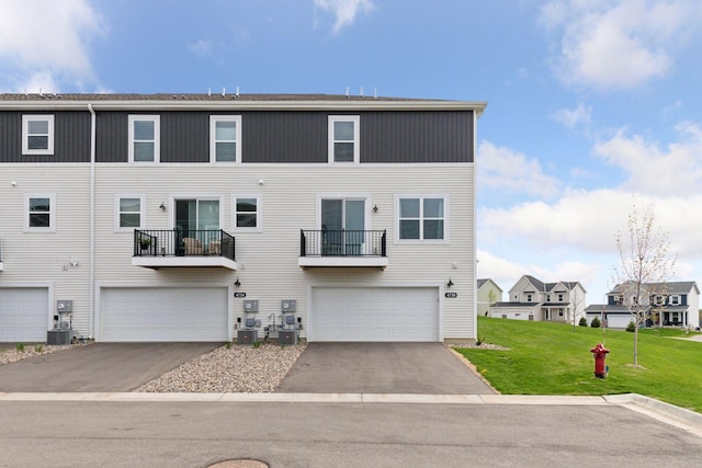 view of front of house with an attached garage, a front lawn, driveway, and a residential view