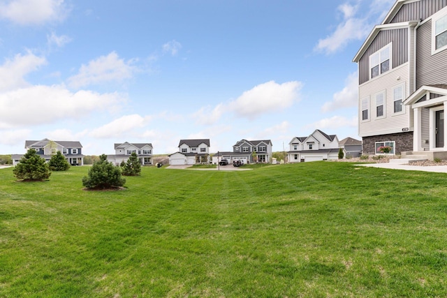 view of green lawn featuring a residential view