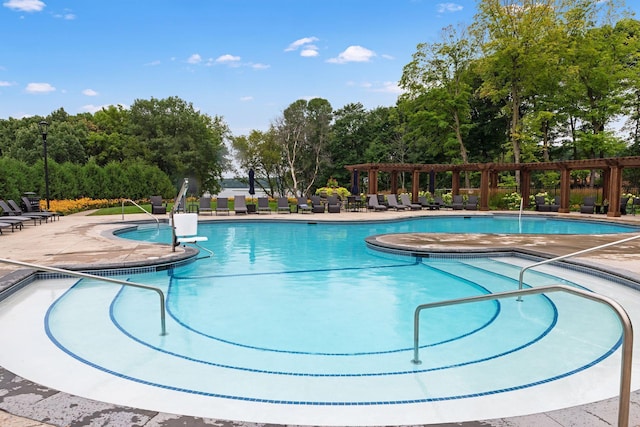 community pool featuring a pergola, a patio area, and view of scattered trees