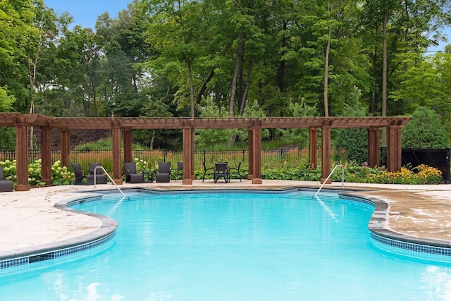 community pool featuring fence and view of wooded area
