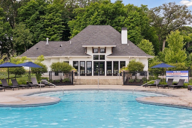 community pool with a patio and fence