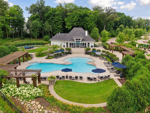 community pool featuring a pergola, a lawn, a patio, and view of scattered trees