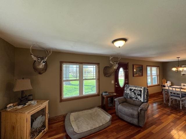 living area with a chandelier and dark wood finished floors